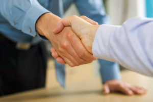 Businessmen shaking hands --- Image by © Mark Adams/Corbis